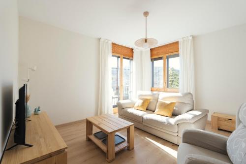 Casa Cauma Apartamento في بني الرزين: غرفة معيشة مع أريكة بيضاء وطاولة