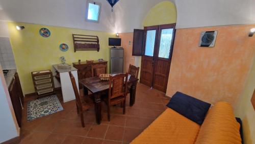 a living room with a table and a kitchen at I Dammusi di Punta Karace in Tracino