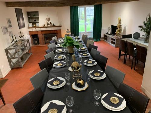 une longue table dans un salon avec des chaises et une table avec de la nourriture dans l'établissement Le Verger de Pauline, à Maslives