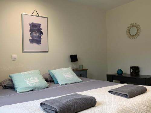 une chambre avec un lit avec deux oreillers dessus dans l'établissement Le Verger de Pauline, à Maslives