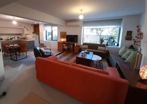 sala de estar con sofá rojo y mesa en Luxurious StoneHouse Trikala, en Tríkala
