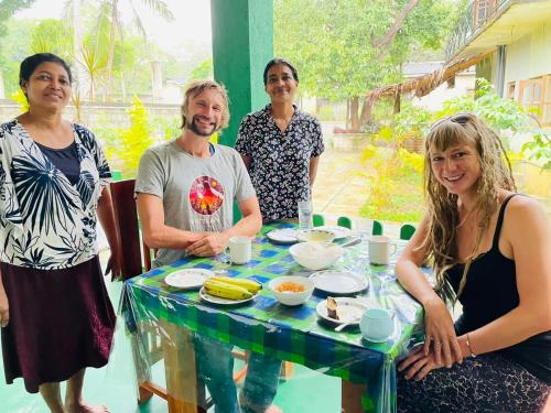 a group of people standing around a table with food at Jm Resort in Dambulla