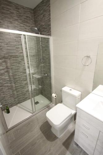 y baño blanco con ducha y aseo. en Cómodo piso en Vallecas by beBalmy, en Madrid