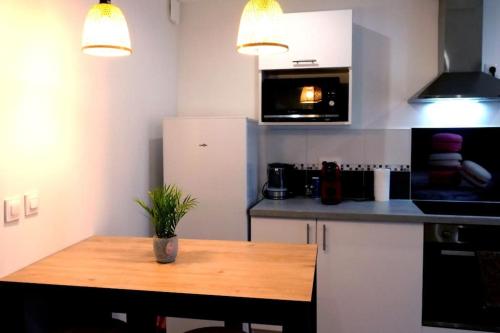a kitchen with a wooden table in a kitchen at L’Impérial 4- CentreVille- WIFI in Étampes