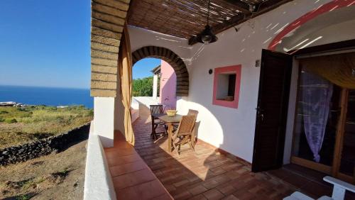 a patio with a table and a view of the ocean at I Dammusi di Punta Karace in Tracino