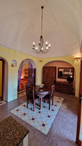 a dining room with a table and chairs and a chandelier at I Dammusi di Punta Karace in Tracino