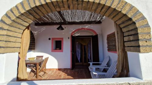 a room with a table and chairs and an archway at I Dammusi di Punta Karace in Tracino