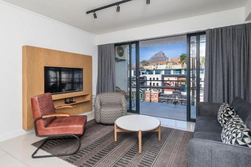 Xenia Aparthotel by Totalstay في كيب تاون: غرفة معيشة مع أريكة وتلفزيون