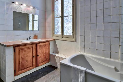 une salle de bain avec une baignoire, un lavabo et un miroir dans l'établissement NOCNOC - Le Minot, à Marseille