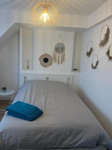 ein Schlafzimmer mit einem Bett mit einem blauen Ordner darauf in der Unterkunft agréable in Noisy-le-Sec