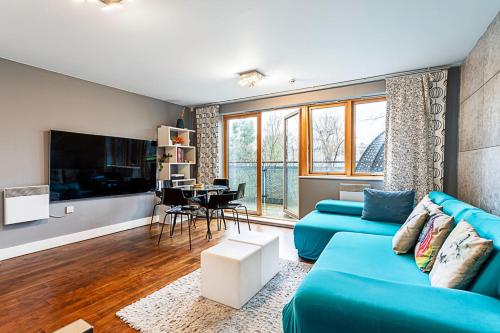 a living room with a blue couch and a table at Modern 2-Bed Flat Bethnal Green in London