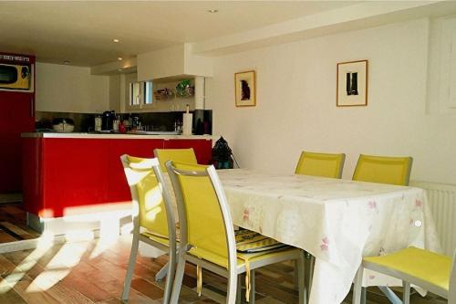 une salle à manger avec une table et des chaises jaunes dans l'établissement la charmante maison d'antan, à Thorigny-sur-Marne