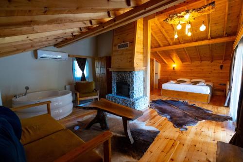 a living room with a fireplace and a bed and a tub at Abant Villa Otel in Bolu