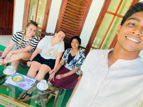a group of people sitting on a glass table at Jm Resort in Dambulla