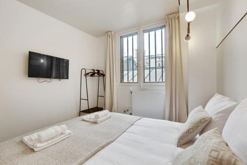 1 dormitorio con 1 cama blanca y TV en la pared en 220 Suite Jessy - Superb Apartment in Paris, en París
