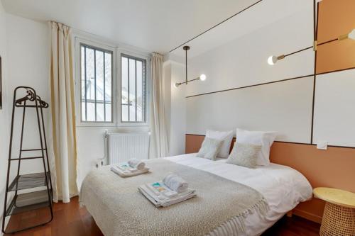 Un dormitorio con una cama con toallas y una escalera en 220 Suite Jessy - Superb Apartment in Paris, en París