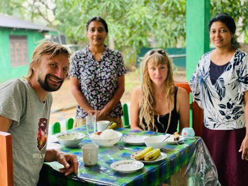 eine Gruppe von Menschen, die um einen Tisch mit Essen stehen in der Unterkunft Jm Resort in Dambulla