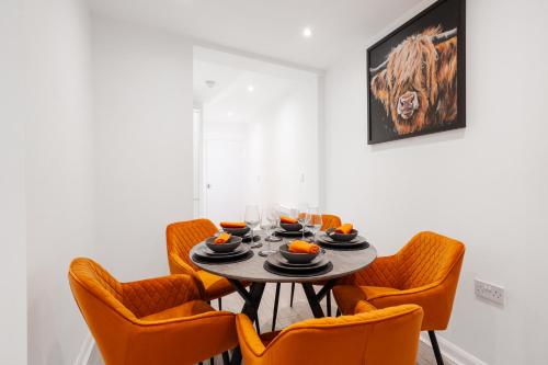 uma sala de jantar com uma mesa e cadeiras laranja em Brighton Apt - 2 Bedroom Free Wi-Fi & Parking em Wallasey