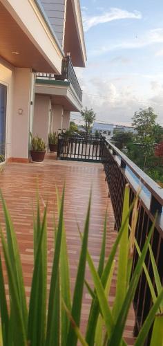 a balcony of a house with a wooden deck at Angkearsel GuestHouse in Kampot