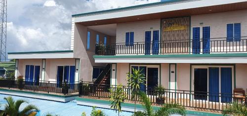 ein Gebäude mit blauen Rollläden neben einem Pool in der Unterkunft Angkearsel GuestHouse in Kampot