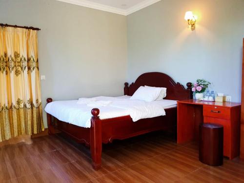 um quarto com uma cama e uma cómoda e uma cama sidx sidx sidx em Angkearsel GuestHouse em Kampot