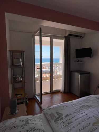 Schlafzimmer mit einem Bett und Meerblick in der Unterkunft Apartment and rooms SIDRO in Petrcane