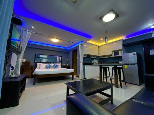 sala de estar con sofá y cocina con iluminación azul en TLT Condotl E-217 at Kiener Hills Condominium, en Mactan