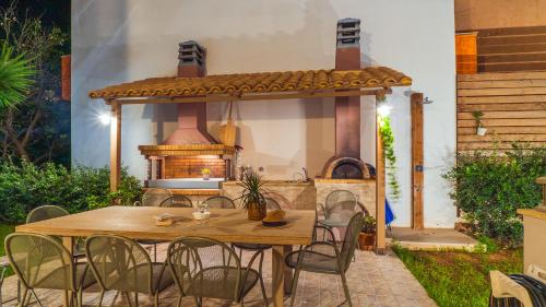eine Außenküche mit einem Tisch und einem Herd in der Unterkunft Vakakis-ME Apartments in Palaiochóra