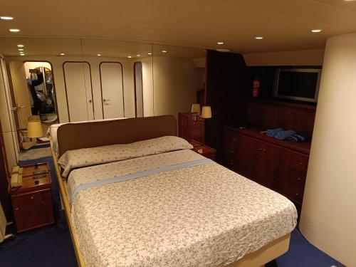a bedroom with a bed and a television in it at Amazing boat to sleep in Barcelona in Barcelona