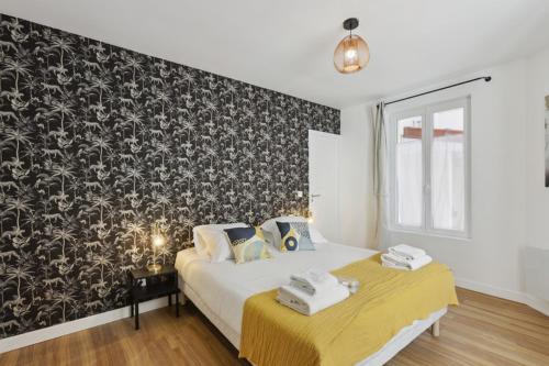 a bedroom with a bed and a black and white wallpaper at 864 Suite Iris - Superb apartment in Montreuil