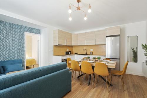 une cuisine et une salle à manger avec une table et un canapé bleu dans l'établissement 864 Suite Iris - Superb apartment, à Montreuil