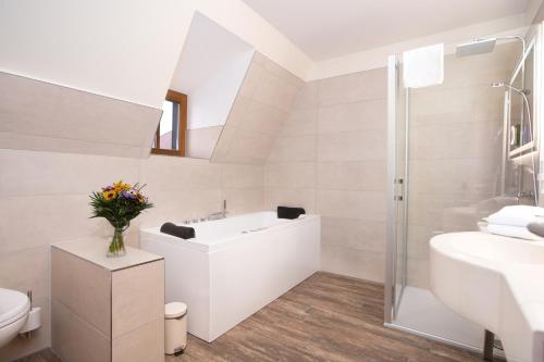 uma casa de banho branca com um lavatório e um WC em Hotel Kloster Nimbschen 4 Sterne em Grimma