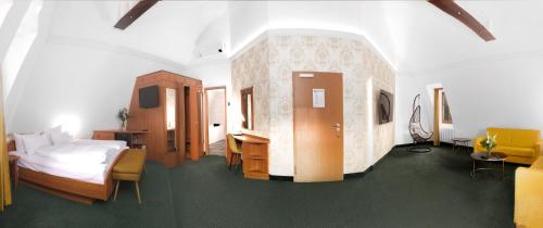 a bedroom with a bed and a desk in a room at Hotel Kloster Nimbschen 4 Sterne in Grimma