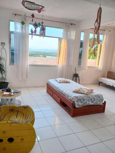 a bedroom with a bed and a view of the beach at Surf café bar e hospedagem in Rio de Janeiro