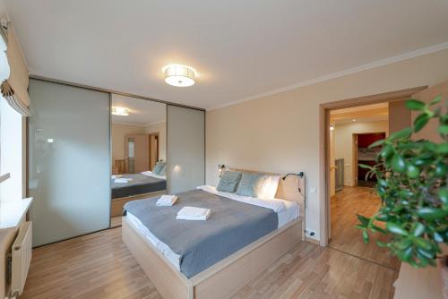 1 dormitorio con cama y espejo grande en Quiet and spacious oasis in Riga center, Parking available, en Riga