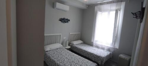 マラガにあるLovely Apartment in Pedregalejoの窓付きの小さな部屋のベッド2台