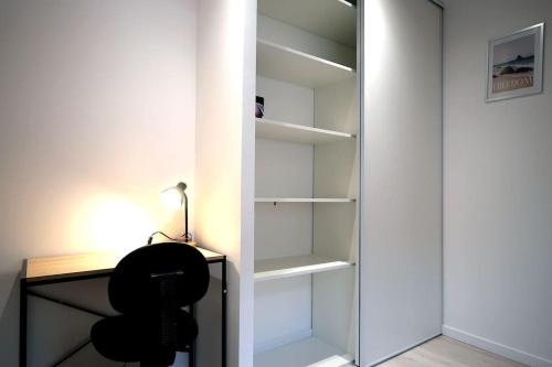 a glass closet with a desk and a lamp at L Imperial 6 -CentreVille- WIFI in Étampes