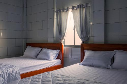 2 camas en una habitación con ventana en Motel KIM PHÁT LUXURY - Núi Cấm 