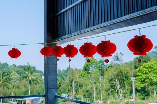 a group of red paper lanterns hanging from a building at Motel KIM PHÁT LUXURY - Núi Cấm in Phum Kokhlăng