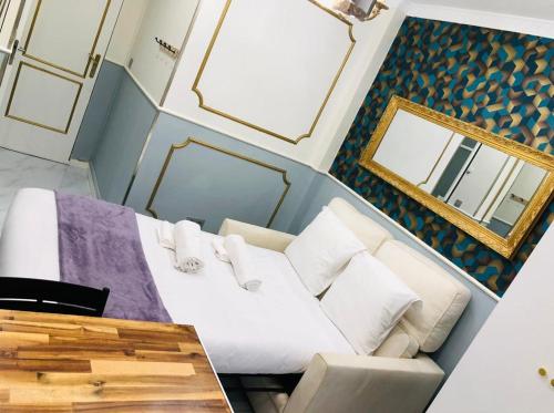 Cette chambre comprend un canapé blanc et un miroir. dans l'établissement Po1-TPSA16-RDC- ROOM Paris 16 ème, à Paris