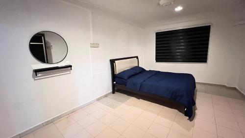 a bedroom with a blue bed and a mirror at Homestay Cikgu Sayang in Melaka