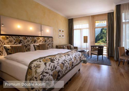 a hotel room with a bed and a living room at Lenkerhof gourmet spa resort - Relais & Châteaux in Lenk
