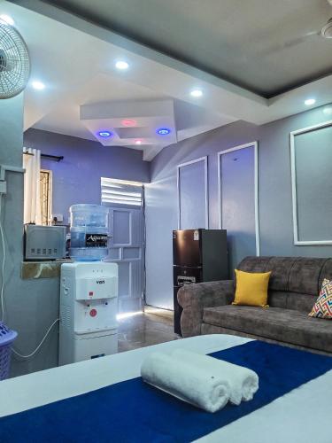 Cathys Studio Apartment في مومباسا: غرفة معيشة مع أريكة ومطبخ
