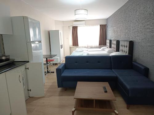 sala de estar con sofá azul y cama en White Crown Apartman ve Yaşam Merkezi, en Estambul
