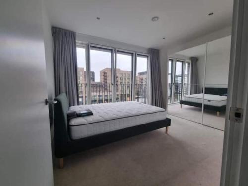 a bedroom with a bed and a large window at ExCeL London-Exclusive 3 Bedroom in North Woolwich