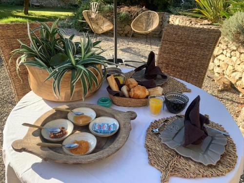 a table with a plate of food and a bowl of fruit at Noccemada "Spirit of Bali" Lodge, Pool & Spa in Saint-Julien