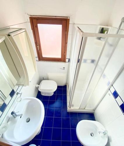 a bathroom with a white sink and a toilet at Appartamento Lucca 2 in San Teodoro