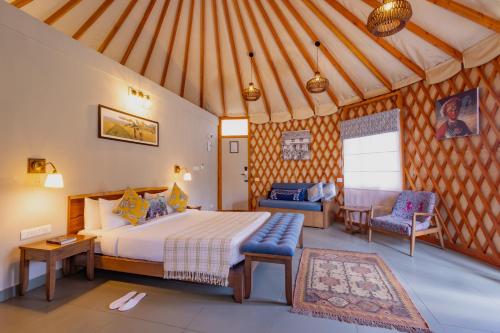 SrimangalaにあるMachaan Wilderness Lodge Nagaraholeのベッドルーム1室(ベッド1台、ソファ付)
