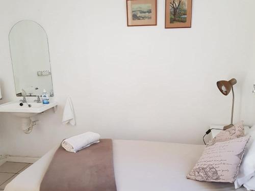 a white room with a sink and a bath tub at Jackie's B&B in East London