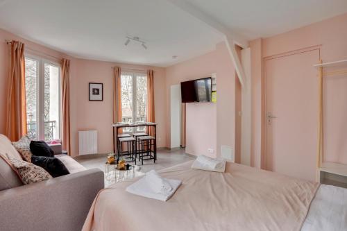 uma sala de estar com uma cama grande e um sofá em 145 Suite Marco - Superbe Appartement à Paris em Paris